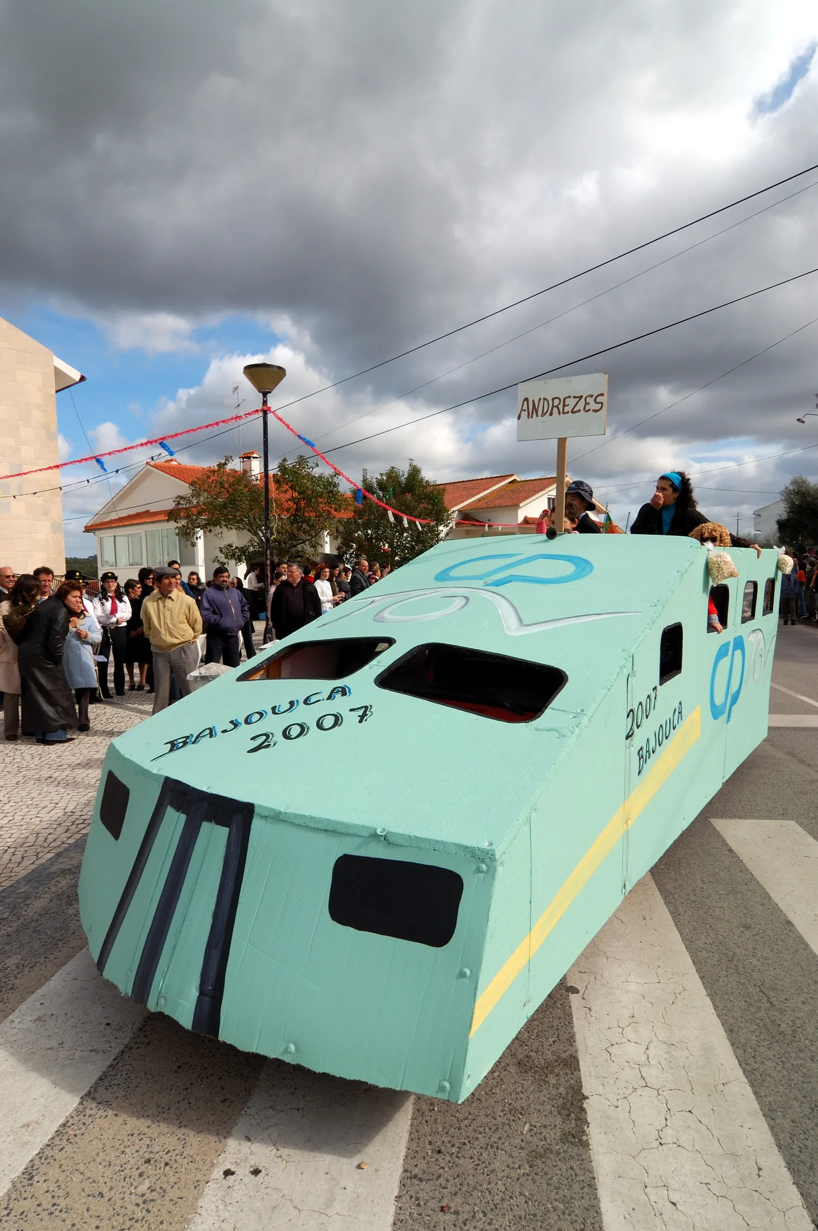 מיצג קרנבל צבעוני בצורת רכבת בתהלוכת רחוב בפורטוגל, קהל צופים בחגיגות החורף