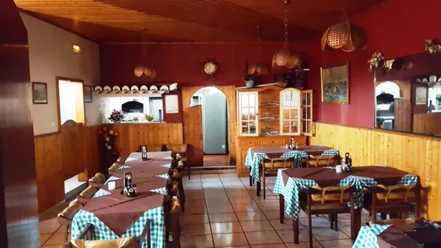 אולם כפרי עם קירות אדומים, חיפוי עץ, מפות משובצות וסלים תלויים