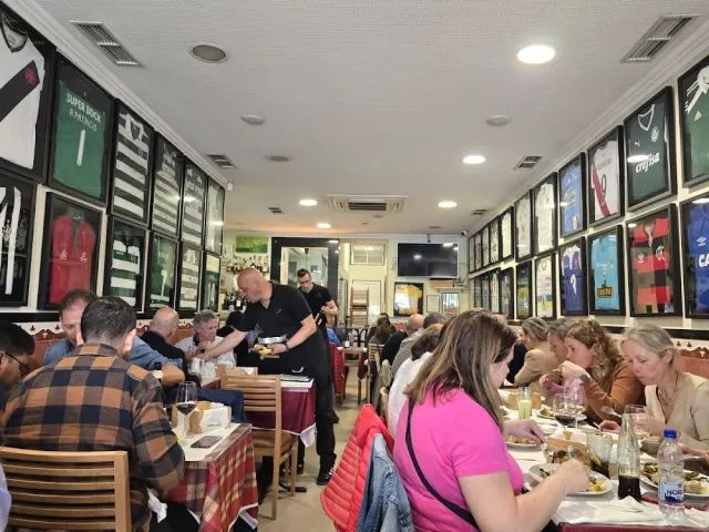 אולם צפוף בסועדים עם חולצות כדורגל ממוסגרות על כל הקירות