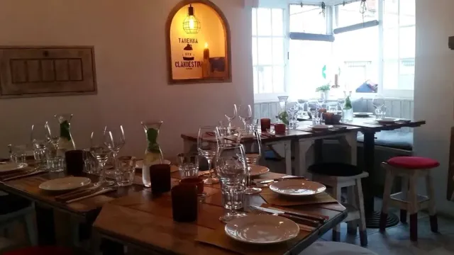 שולחנות עץ ערוכים בכוסות, גומחה מוארת בקיר וספסל ליד החלון