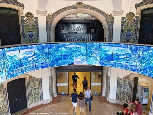 כניסה מקומרת עם חיפוי אריחים כחולים ומבקרים נכנסים
