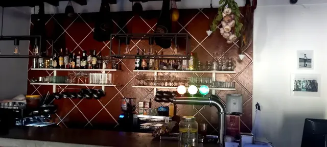 גב בר עם מדפי בקבוקים, כוסות תלויות, מקלעת שום וברז שתייה
