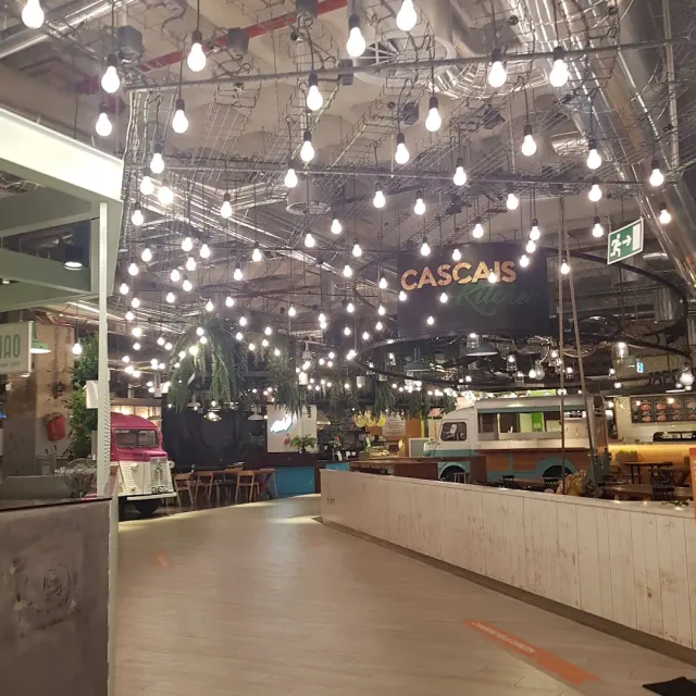 אזור מזון עם עשרות נורות תלויות מהתקרה ודוכנים בצורת ואן