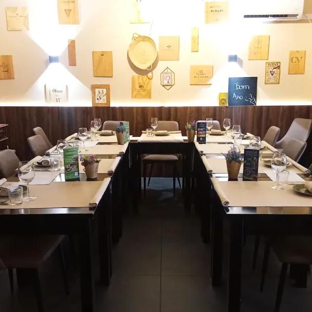 שולחנות ערוכים בצורת פרסה מול קיר עם לוחות עץ ממארזי יין
