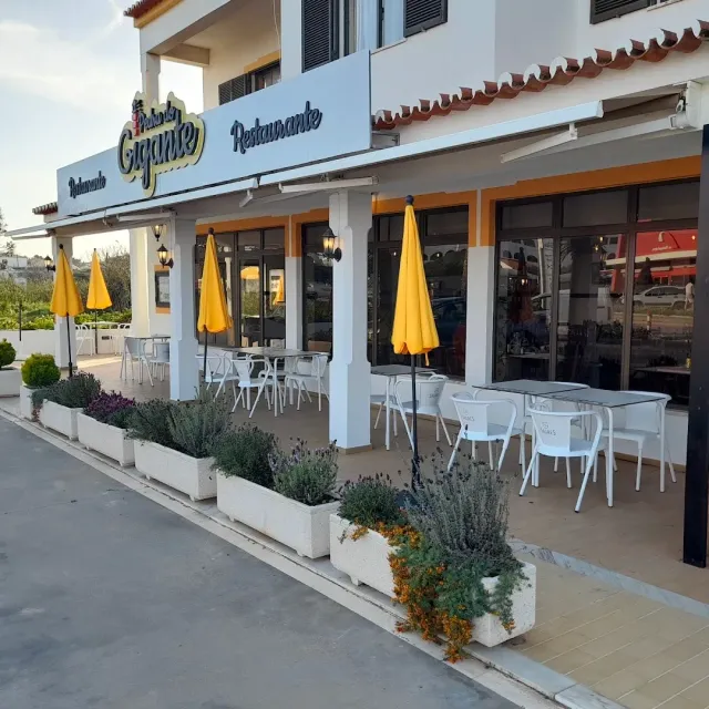 מבנה לבן עם שמשיות צהובות סגורות, כיסאות לבנים ואדניות לבנדר