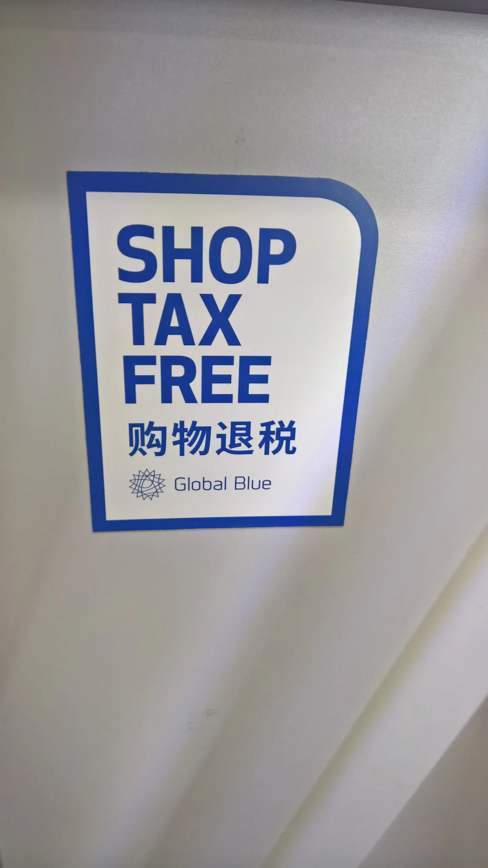 שלט Global Blue של Shop Tax Free בכניסה לחנות, מסמל החזר מס ערך מוסף לתיירים וחיסכון בקניות בפורטוגל